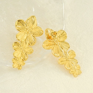 Elegant gold plated titanium steel triple floral drop earrings for women on beige linen