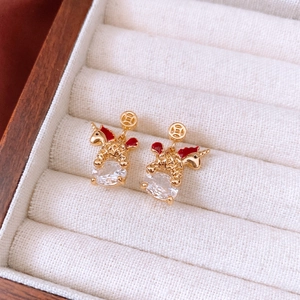 Detailed macro shot of vintage 18k gold plated unicorn earrings with red enamel and crystals