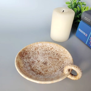 Modern ceramic candle holder with speckled glaze finish and a minimalist side handle