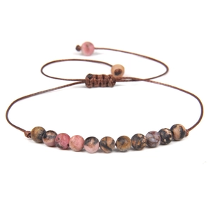 Detailed macro of 4mm natural stone beads with adjustable brown braided cord closure