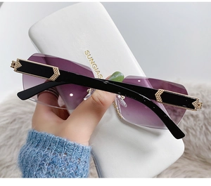 Detail of rimless sunglasses with purple gradient lenses and gold metal accents