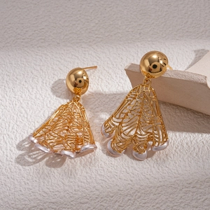 Vintage 18K gold-plated hollow mesh earrings with white bead drops on a stone background