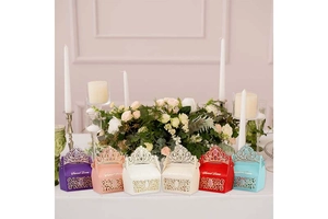 Macro detail of laser-cut crown candy boxes in multiple colors for wedding party favors