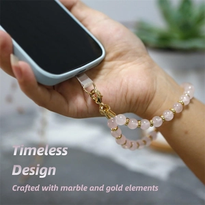 8mm pink zebra stone and marble beaded phone strap with gold clasp on wrist