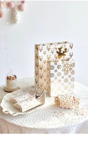 Elegant white and gold Christmas gift boxes and paper bags with reindeer and snowflake patterns