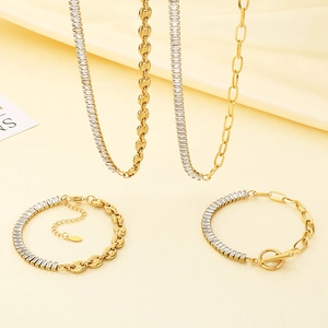 Gold chain jewelry set featuring crystal tennis chain and OT toggle clasp on cream silk