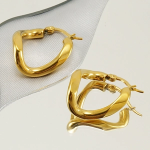 Chic twisted geometric gold earrings in stainless steel on a reflective surface