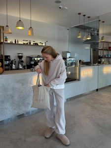 Dames hoodie en joggingbroek set met stijlvolle canvas draagtas in een café