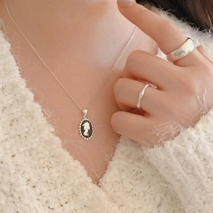 Close-up of 925 sterling silver Elizabeth cameo necklace worn on model with matching ring