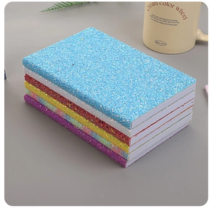 Stack of glitter cover notebooks in blue, white, red, yellow, green and purple colors