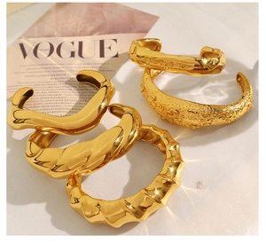 Detail showing four gold irregular lava texture cuff bracelets on a fashion magazine