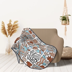 Detail view of a soft flannel blanket with boho abstract patterns on a cozy armchair