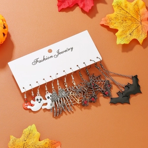 Flat lay of a Halloween earring set featuring ghosts, pumpkins, and spiders on an orange backdrop