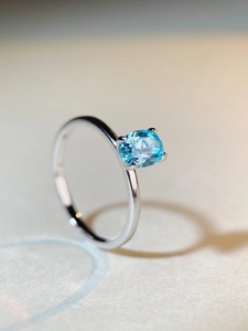 Macro shot of an oval cut blue gemstone set on a minimalist silver band