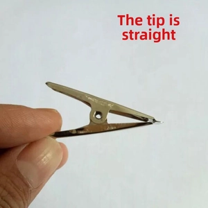Close-up of a silver stainless steel alligator clip with fine serrated teeth held by hand