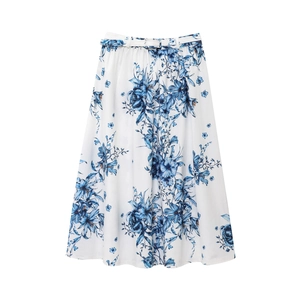 Detail of white maxi skirt featuring blue floral print and matching fabric belt tie