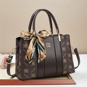 Deep brown FOSIDIRI tote bag with silk scarf detail on a minimalist wooden base