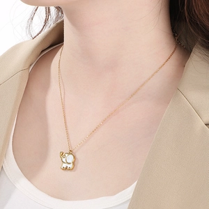 Elegant gold elephant pendant necklace with white inlay on model for creative styling
