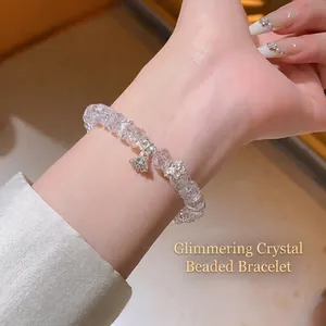 Élégant bracelet en perles de cristal avec pendentif lotus au poignet d'une femme