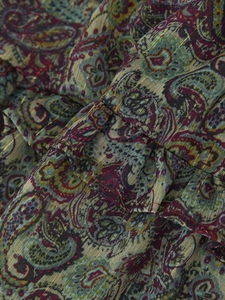 Detailed macro view of chiffon fabric with paisley print and subtle metallic gold threading