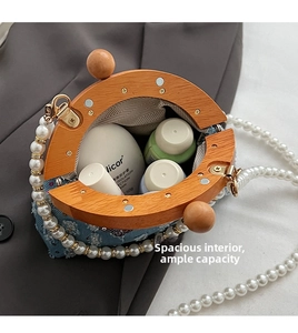 Macro view of blue denim crossbody bag with wood frame and pearl strap details