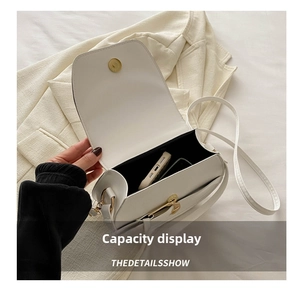 Top-down view of white minimalist crossbody bag showing internal space and magnetic buckle
