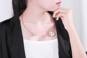 Detail of rose gold stainless steel open choker necklace with two large zircon stones