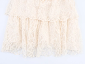 Detailed close-up of beige tiered lace skirt with delicate floral embroidery and ruffles