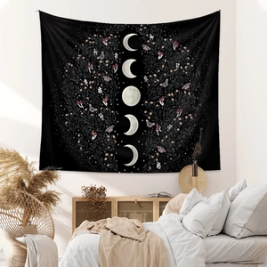 Detail of bohemian moon phase tapestry with floral butterfly patterns on a black fabric