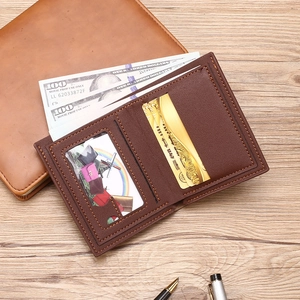 Slim brown leather bifold wallet for men featuring multiple card slots on wooden desk