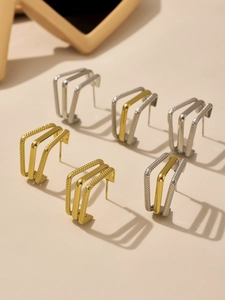 Macro detail of triple-layer square hoop earrings in gold, silver, and two-tone finishes
