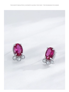 Macro shot of S925 silver earrings with oval ruby stones and white accent diamonds