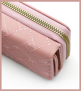 Detail of pink PU leather wallet with heart embroidery and gold metal zipper closure
