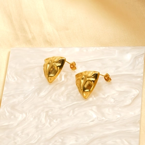 Irregular textured 18k gold plated stainless steel stud earrings on marble and silk