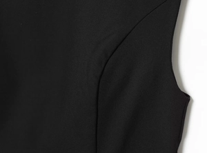 Detailed close-up of side seams and smooth hemline on black slim-fit mini dress