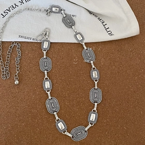 Detail of vintage silver metal waist chain with oval textured links and lobster clasp closure