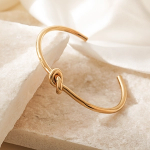 Bracelet jonc en acier inoxydable plaqué or 18K avec nœud élégant et fini brillant