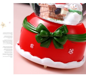 Close-up of red Christmas crystal ball base with green bow and snowflake patterns