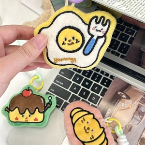 Macro detail of cartoon plush breakfast pendants with fine embroidery and colorful lanyards