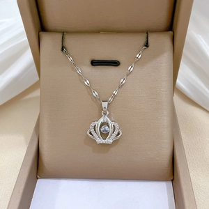 Close-up of sparkling crown pendant necklace with center zircon in a luxury jewelry box