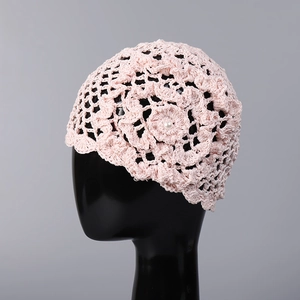 Détail d'un bonnet au crochet rose fait main avec fleur 3D et perle de décoration