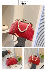 Detail of pink velvet shell bag with pearl handle and golden chain strap in soft lighting