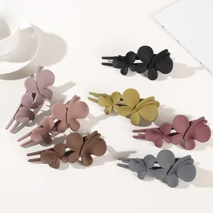 Detail view of double butterfly matte resin hair clips in six assorted muted colors
