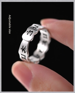 Macro shot of adjustable silver ring with etched Sanskrit mantra and vintage finish