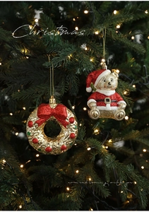 Golden Christmas wreath with red bow and gold bear ornament on a lighted tree