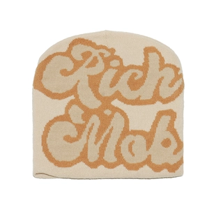 Detailed close-up of cream and brown knit beanie with bold Rich Mob jacquard pattern