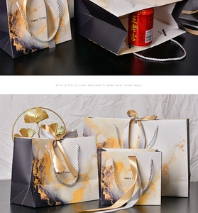 Various sizes of marble pattern gift bags with elegant silver handles and ribbons