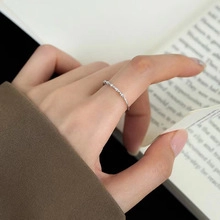 Close-up of minimalist silver star ring with zircons and chain detail for women