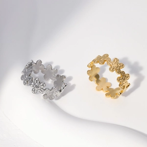 Close-up of gold and silver stainless steel rings with hollow daisy floral patterns