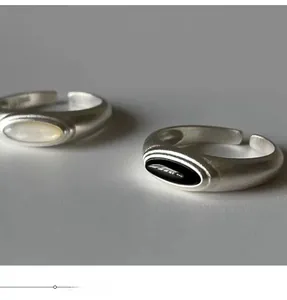Macro detail of matte silver rings with oval black onyx and white mother of pearl inlay